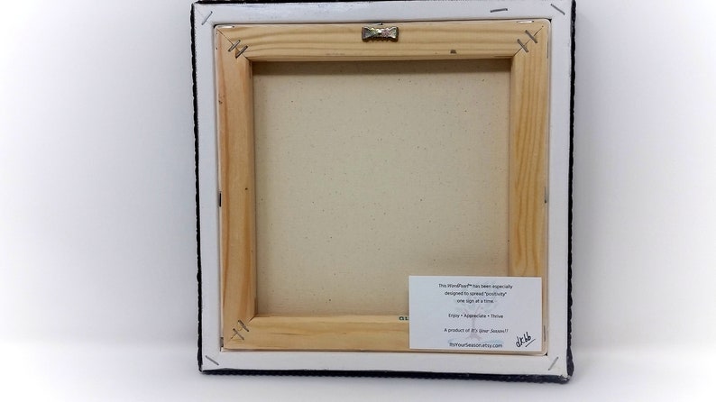 May include: The back of a stretched canvas painting with a wooden frame. A white label with black text is attached to the frame. The text reads "The MindfulPaw&trade; has been expertly designed to satisfy your creativity one light at a time. Enjoy - Appreciate - Thrive A product of "The Paw Season"  www.thepawseason.etsy.com"