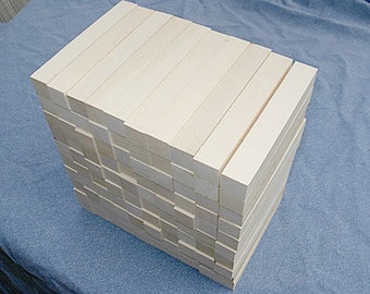 Puede incluir: Una pila de tacos de madera natural sin terminar, dispuestos en forma rectangular. Los tacos son todos del mismo tamaño y están apilados cuidadosamente uno encima del otro.