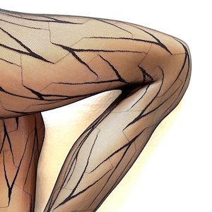 May include: Sheer black tights with a geometric, cracked-glass pattern. The design features dark lines that create a network of shapes across the leg, offering a stylish and modern look. The tights are semi-opaque, allowing the skin tone to show through.