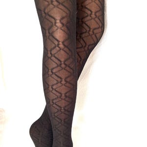 May include: Sheer black tights featuring a repeating geometric diamond pattern. The hosiery has a semi-transparent finish that reveals the skin tone underneath, creating a contrast between the dark fabric and the intricate lattice design.