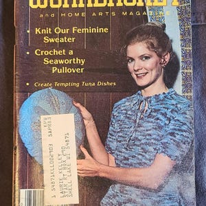 May include: Vintage "Workbasket" magazine cover featuring a woman wearing a blue knit sweater. The magazine's title is in yellow and blue, with text promoting knitting and crochet projects. A price tag is visible.