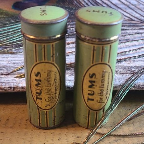 Set of 2 vintage/antique Tums push up tins Only one has pot of gold on back.