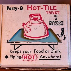 May include: A vintage "Party-Q Hot-Tile Trivet" box. The box features a red and white illustration of a teapot on a blue surface. Text includes "Keeps your Food or Drink Piping HOT Anywhere!" and "In 3 Decorator Tile Colors."