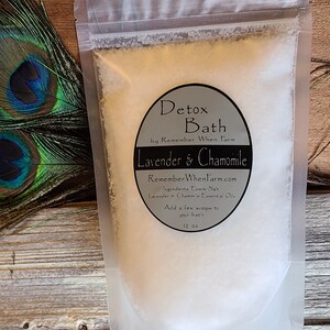May include: A white pouch filled with white bath salts. The pouch has a black label that reads "Detox Bath by Remember When Farm Lavender & Chamomile RememberWhenFarm.com Ingredients: Epsom Salt, Lavender & Chamomile Essential Oils Add a few scoops to your bath 12 oz"