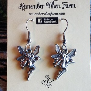 May include: Silver fairy dangle earrings with a silver hook. The earrings are on a card with the text "Remember When Farm" and "rememberwhenfarm.com".
