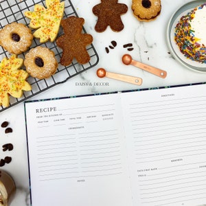 May include: A recipe journal with a black cover and a floral design. The journal has sections for prep time, cook time, total time, servings, difficulty, ingredients, notes, date first made, this is, and memories. The journal is open to a blank page with lines for writing.