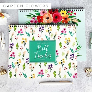 May include: A white spiral bound journal with a teal green cover that says "Daisy and Decor Bill Tracker Journal". The cover has a floral pattern with pink, yellow, and purple flowers on a white background.