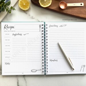 May include: An open recipe book with a teal cover and white pages. The book has a spiral binding and is titled "Recipe" and "Directions". The book is open to a page with a section for ingredients, prep time, cook time, total time, difficulty, and notes. The opposite page has a section for directions and memories.
