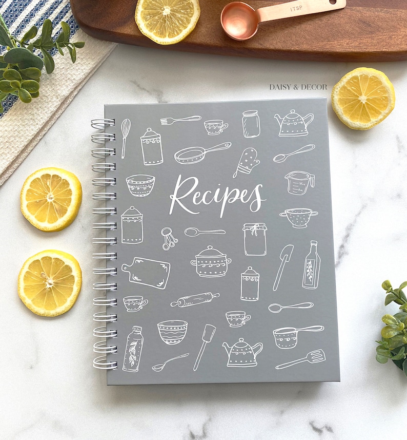 May include: Gray spiral bound recipe book with white illustrations of kitchen tools and the word "Recipes" on the cover.