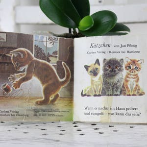 K&ouml;nnte beinhalten: Ein altes Kinderbuch mit dem Titel "K&auml;tzchen von Jan Pfloog" vom Carlsen Verlag. Das Buch zeigt Illustrationen von Katzen und den Text "Wenn es nachts im Haus poltert und rumpelt - was kann das sein?"