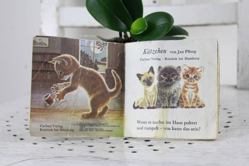 K&ouml;nnte beinhalten: Ein altes Kinderbuch mit dem Titel "K&auml;tzchen von Jan Pfloog" vom Carlsen Verlag. Das Buch zeigt Illustrationen von Katzen und den Text "Wenn es nachts im Haus poltert und rumpelt - was kann das sein?"