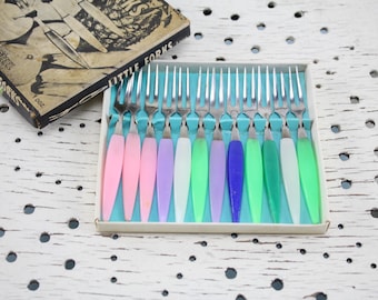 May include: A set of 12 colorful little forks in a white box. The forks have silver tines and plastic handles in pink, purple, green, and blue.