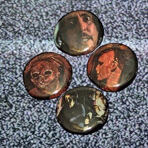 May include: Four round buttons with different horror movie characters. The buttons are red, orange, and black with images of a man with a bloody face, a man with a skull face, a man with a bloody face, and a man with a bloody face.