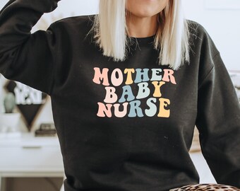 May include: Black sweatshirt with the text "MOTHER BABY NURSE" in rainbow colors. The text is in a retro font style.