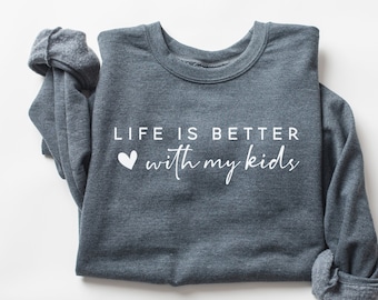 以下が含まれることがあります： 白い文字で「LIFE IS BETTER with my kids」と書いてある、濃いグレーのトレーナー。小さな白いハートも描かれている。