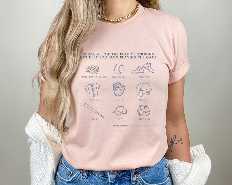 Peut inclure: Un t-shirt rose avec un motif sur le th&egrave;me du baseball. Le motif pr&eacute;sente une citation de Babe Ruth&nbsp;: &laquo;&nbsp;Ne laissez jamais la peur de frapper un home run vous emp&ecirc;cher de jouer&nbsp;&raquo;. Le motif comprend &eacute;galement des illustrations d&rsquo;&eacute;quipements de baseball, notamment une batte, une balle, un gant, une casquette, des crampons et des graines de tournesol.