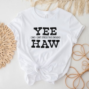 Op de afbeelding: Wit T-shirt met zwarte tekst die "Yee (and I can't stress this enough) Haw" luidt.