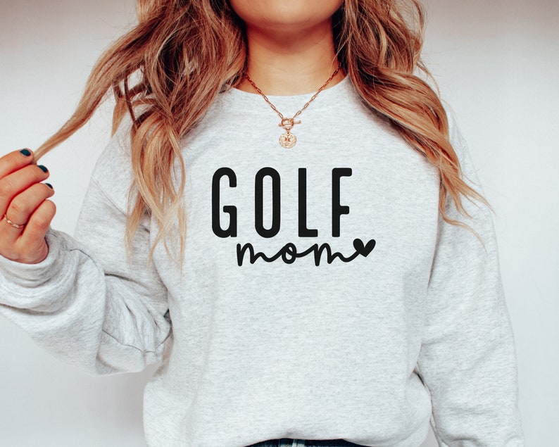 May include: A gray sweatshirt with the text "GOLF mom" in black lettering with a small heart next to the word "mom".