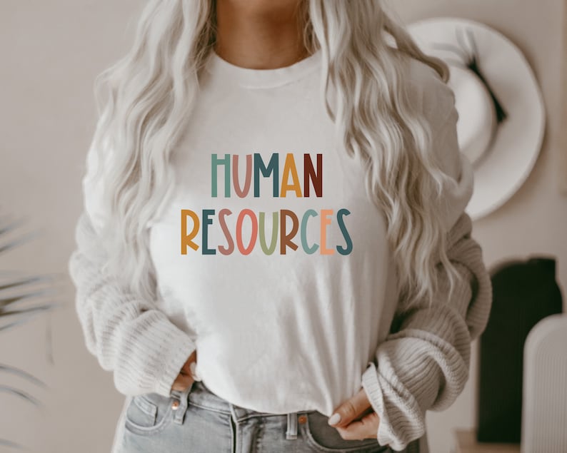 May include: A white t-shirt with the text "HUMAN RESOURCES" in colorful, stylized letters.