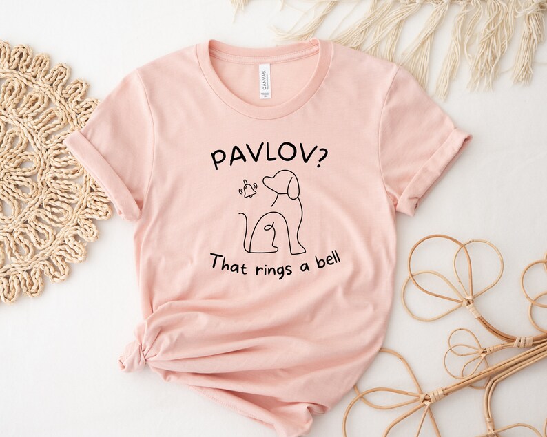 May include: A pink t-shirt with a black graphic of a dog and a bell with the text "Pavlov? That rings a bell."