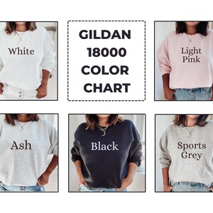May include: A color chart for Gildan 18000 sweatshirts. The chart displays six different sweatshirt colors: white, light pink, ash, black, and sports grey. Each sweatshirt is shown on a person.