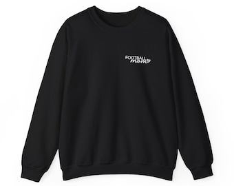 May include: A black long-sleeve crewneck sweatshirt featuring the white text "FOOTBALL mom" with a small heart icon printed on the upper left chest area. The garment has a ribbed neckline, cuffs, and hem, providing a clean and simple design.