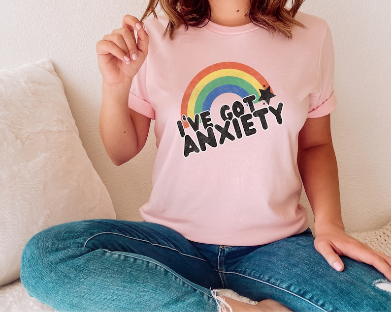 May include: A pink t-shirt with a rainbow and a star graphic. The text on the shirt reads "I've got anxiety".