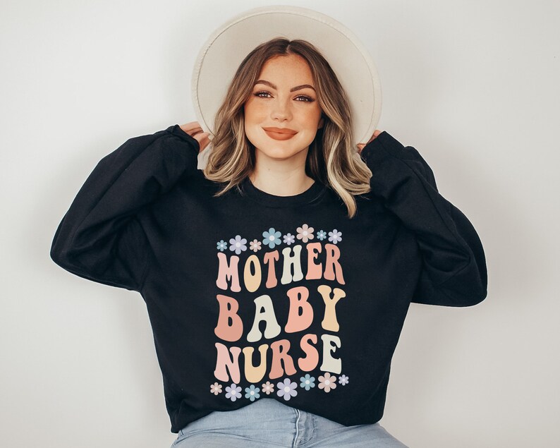 May include: Black sweatshirt with a colorful graphic that says "Mother Baby Nurse" surrounded by small flowers.