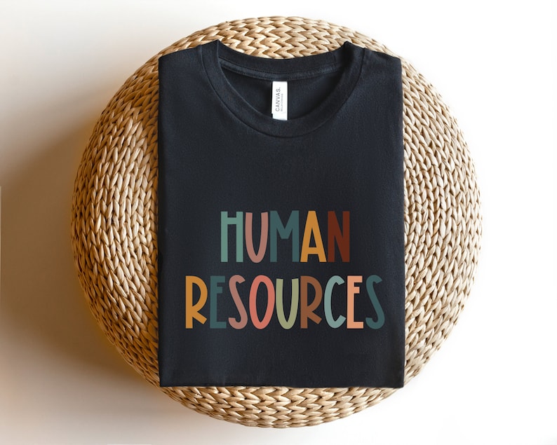 May include: Black t-shirt with the text "HUMAN RESOURCES" in colorful, stylized letters.