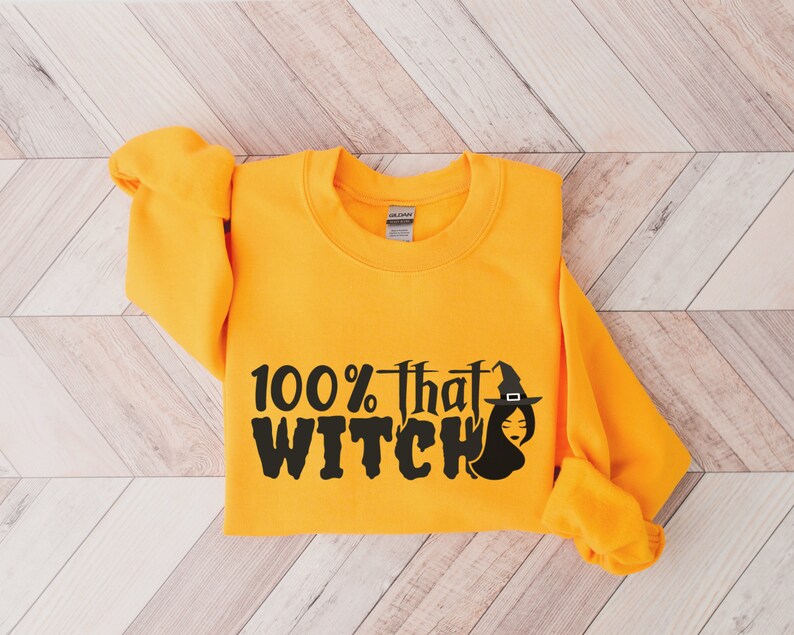 May include: A yellow sweatshirt with the text "100% that WITCH" in black with a witch graphic.