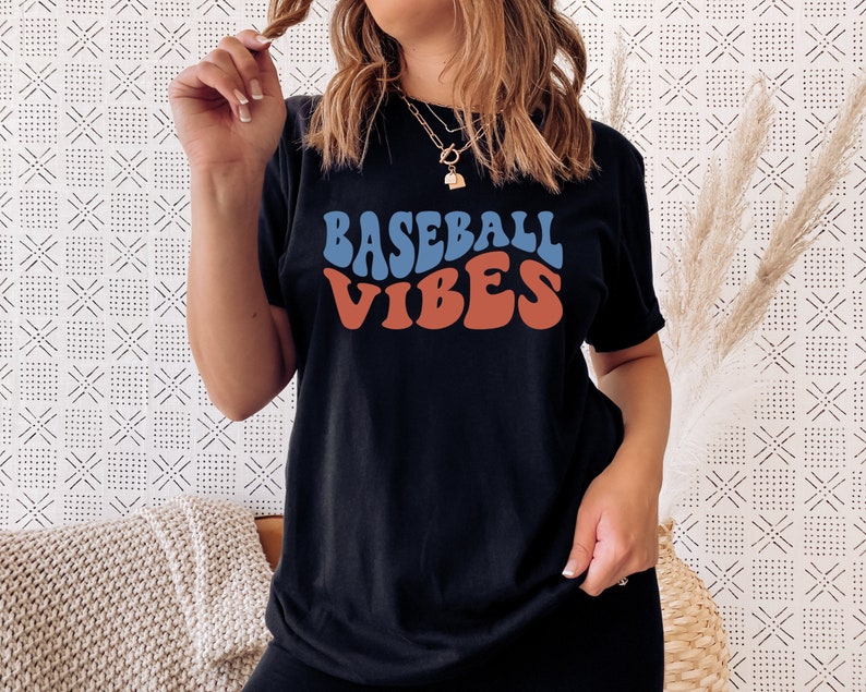 May include: A black t-shirt with the text "BASEBALL VIBES" in a retro, colorful font.