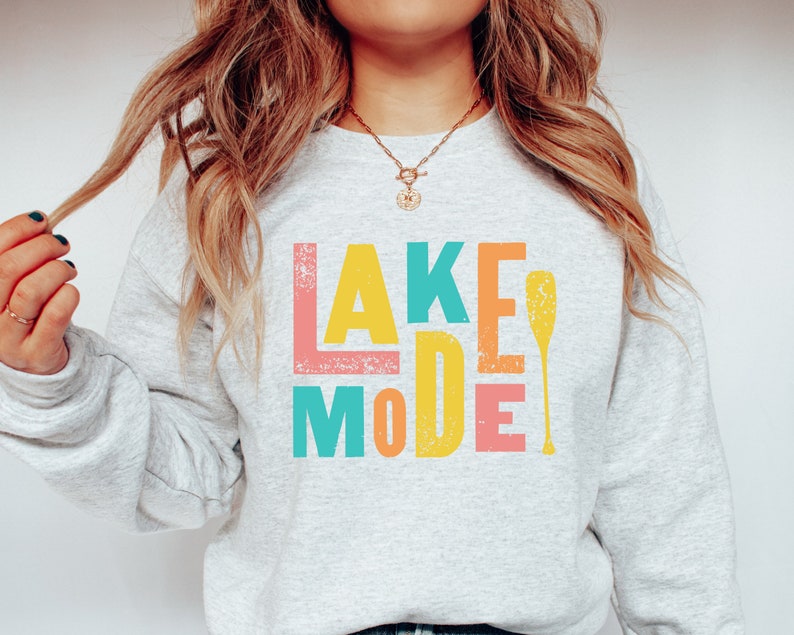 May include: A gray sweatshirt with the text "LAKE MODE" in colorful block letters and a yellow paddle graphic.