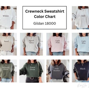 May include: Color chart for Gildan 18000 crewneck sweatshirts. The chart shows 10 different colors: white, ash, sand, sport grey, light pink, light blue, military green, forest green, dark heather, and black.