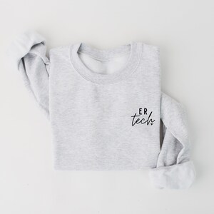 May include: A gray sweatshirt with the text "ER tech" printed on the left chest.
