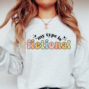 May include: A light gray sweatshirt with the text "my type is fictional" in rainbow-colored letters.