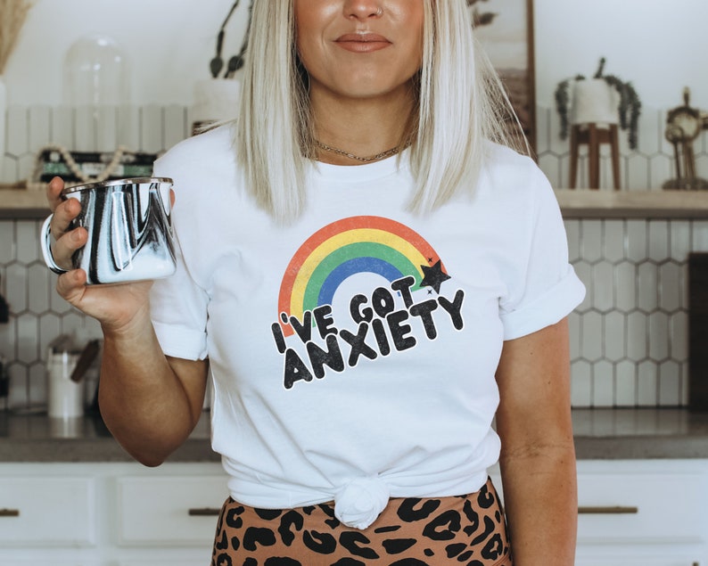 May include: White t-shirt with a rainbow and the text "I've got anxiety" in black lettering.