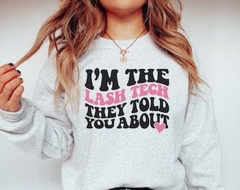 May include: A gray sweatshirt with the text "I'm the lash tech they told you about" in black with a pink heart.