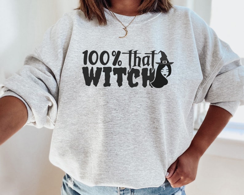 May include: A gray sweatshirt with the text "100% that WITCH" in black with a black silhouette of a witch wearing a hat.