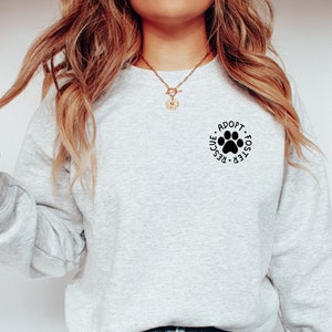 May include: A gray sweatshirt with a black paw print and the text "Adopt. Foster. Rescue." around it.