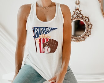 May include: White tank top with a graphic of a baseball glove, popcorn, and a pennant that says "Play-Ball".