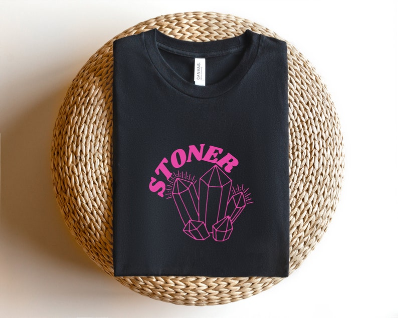May include: Black t-shirt with the word "STONER" in pink letters and a pink crystal graphic.