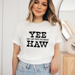Op de afbeelding: Wit T-shirt met zwarte tekst die "Yee (and I can't stress this enough) Haw" zegt