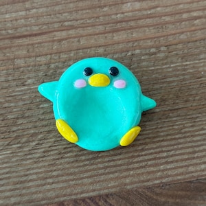 Pedra da preocupação em forma de pássaro, feita à mão em argila polimérica colorida.