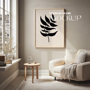 May include: A framed art print featuring a black leaf design on a cream background. The artwork is displayed in a light wood frame. The words "INTERIOR FRAME MOCKUP" are printed at the top of the frame.