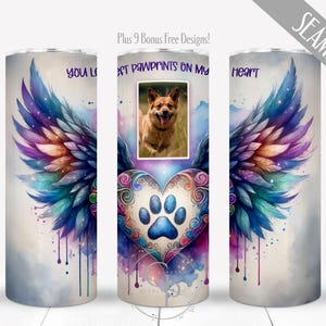 May include: A seamless tumbler design featuring a dog photo, angel wings, and a heart with paw prints. The wings are in shades of blue, purple, and teal. The text reads "You left pawprints on my heart."