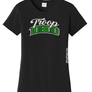 Puede incluir: Camiseta negra con un dise&ntilde;o de purpurina blanco y verde que dice "Troop 1080".