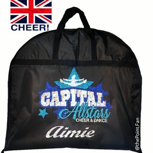 May include: Black garment bag with a blue and white glitter logo that says "Capital Allstars Cheer & Dance" and the name "Aimie" underneath.