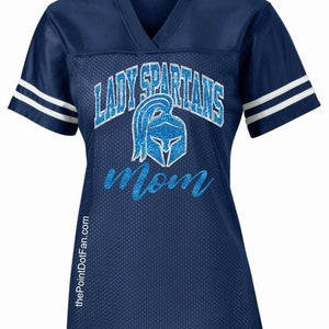 May include: Navy blue jersey with white stripes on the sleeves. The jersey has a blue glitter design that says "Lady Spartans Mom" with a silver glitter Spartan helmet.