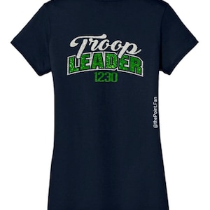 K&ouml;nnte beinhalten: Marineblaues T-Shirt mit gr&uuml;nem Glitzertext, der "Troop Leader 1230" lautet.
