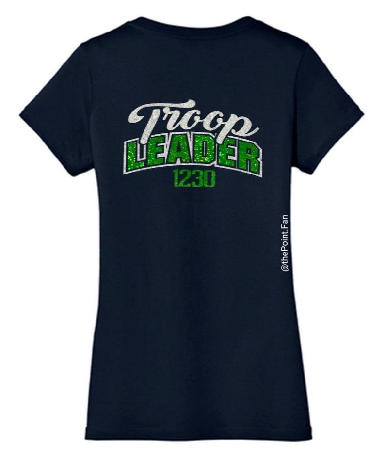 K&ouml;nnte beinhalten: Marineblaues T-Shirt mit gr&uuml;nem Glitzertext, der "Troop Leader 1230" lautet.